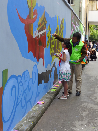 大手拉小手共绘墙体