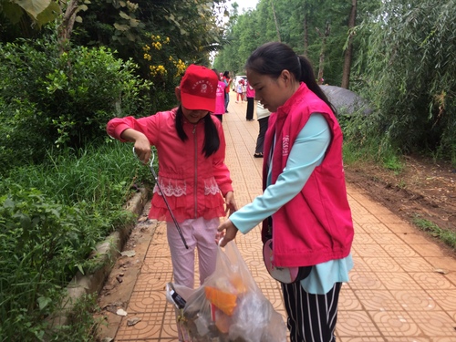 巾帼志愿者带着孩子清理河岸垃圾